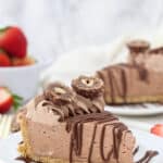 a side view of a slice of nutella pie drizzled with chocolate and covered with ferrero rocher