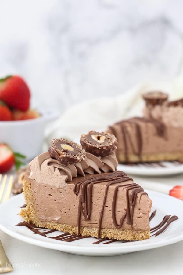 a side view of a slice of nutella pie drizzled with chocolate and covered with ferrero rocher