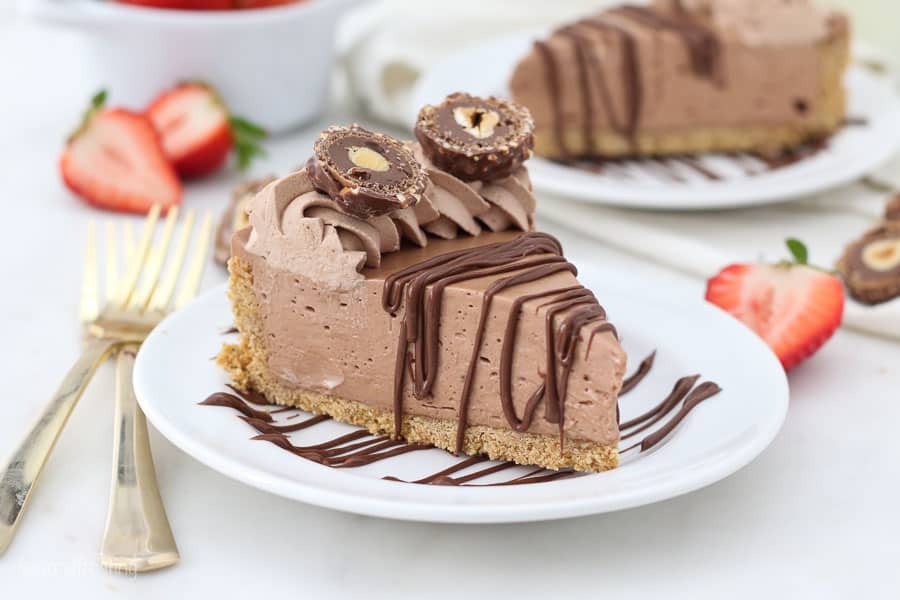 a slice of nutella pie on a white plate with gold forks