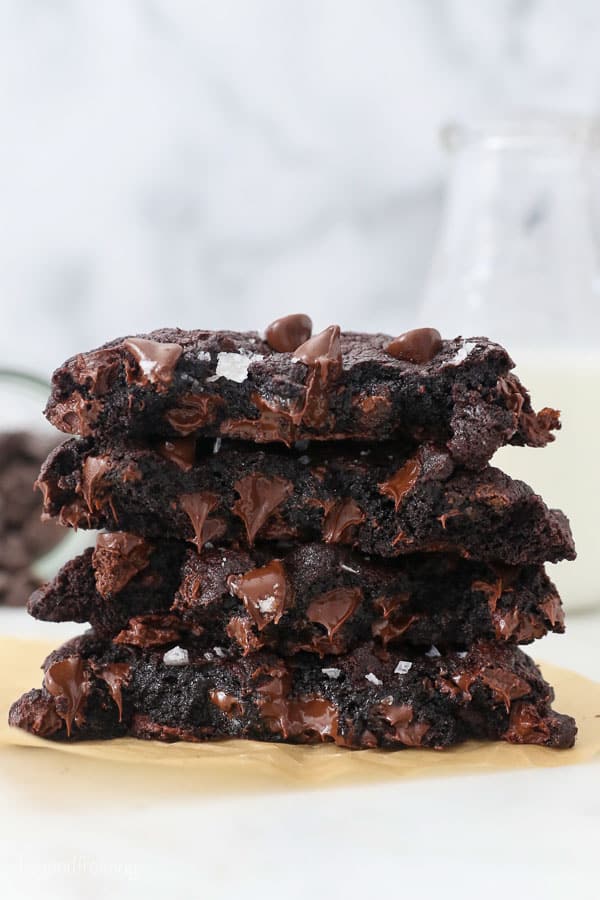 A stack of 4 half cookies showing the melty chocolate chips inside
