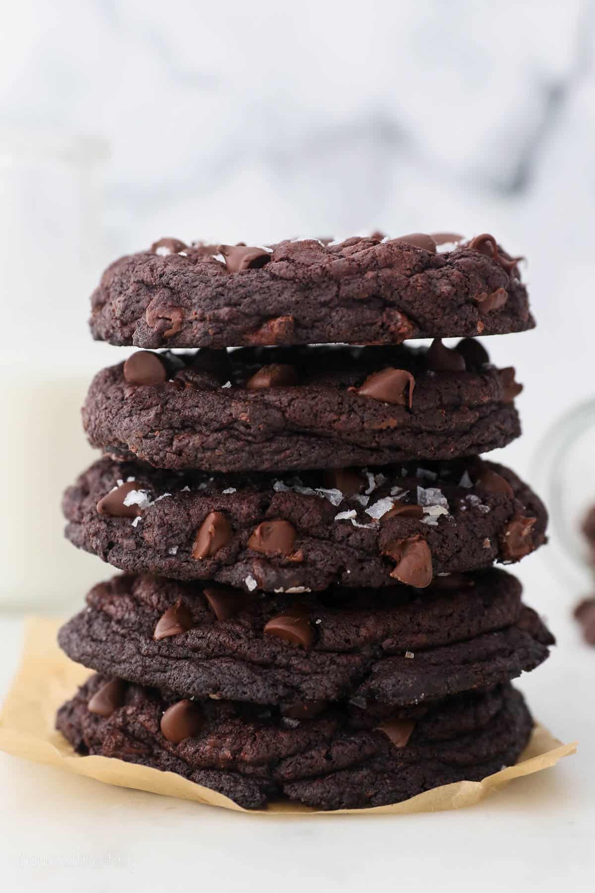 A stack of chocolate cookies on a piece of parchment paper.