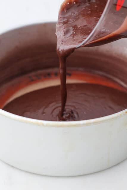 Chocolate cake batter poured into a round cake pan.