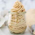 a glass jar filled with piped peanut butter buttercream
