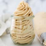 Swirled peanut butter frosting in a glass jar.