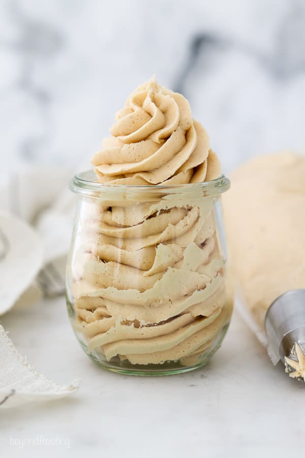 a glass jar filled with piped peanut butter buttercream