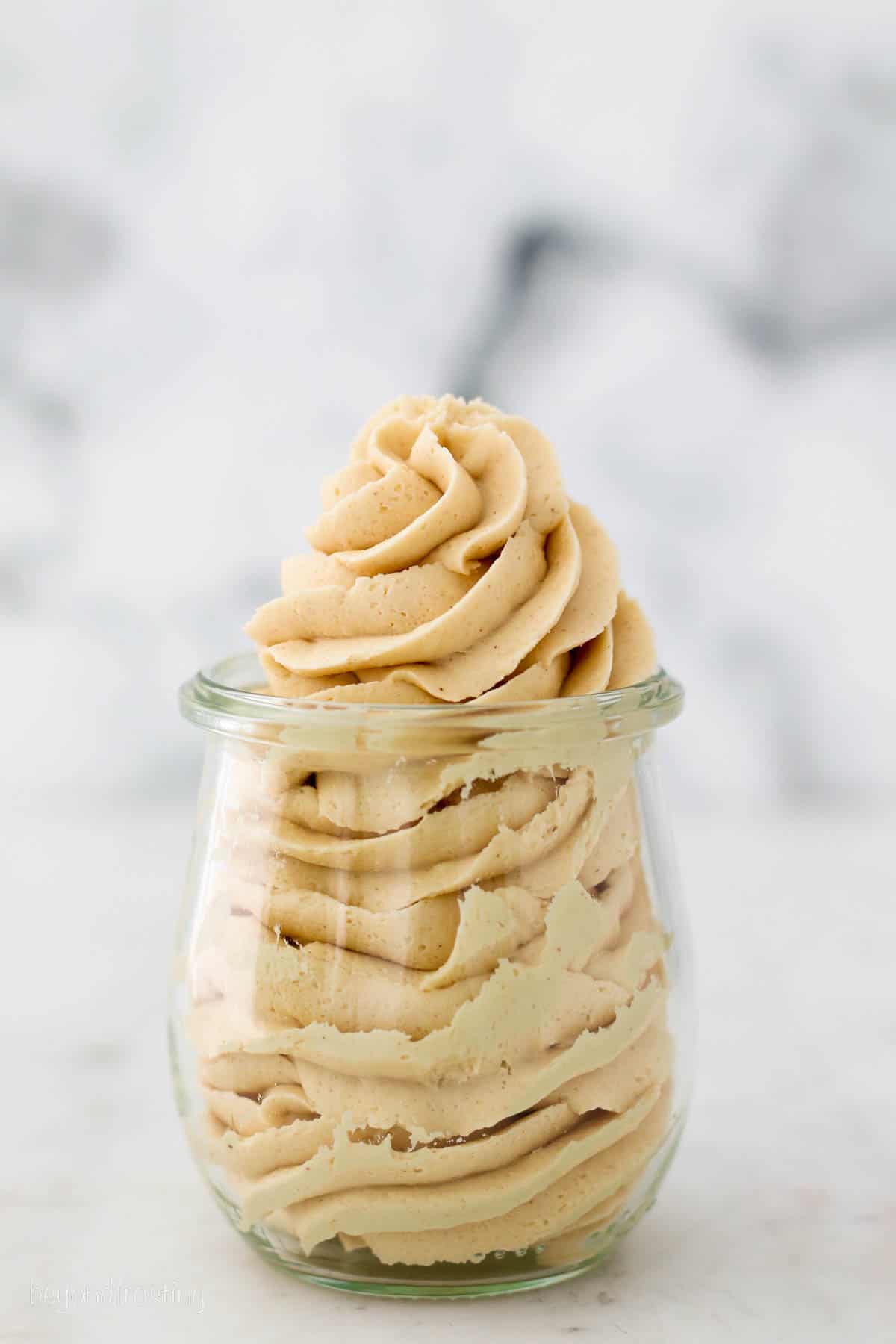 Swirled peanut butter frosting in a glass jar.