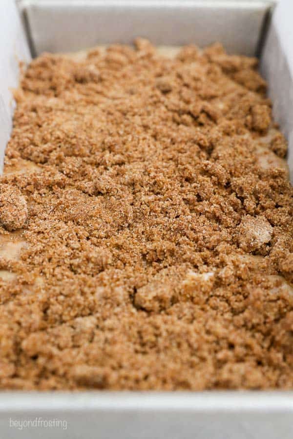 a close up of streusel on top of a loaf pan prior to baking
