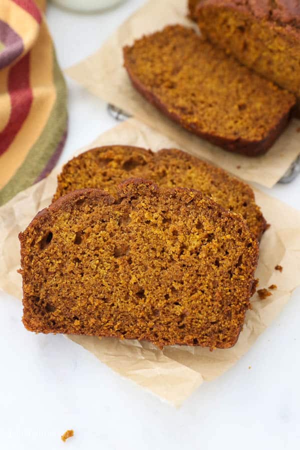 two slices of pumpkin bread on a piece of brown parchment paper