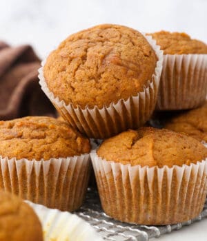 Close up of a pile of pumpkin muffins on a plate.
