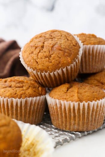 Close up of a pile of pumpkin muffins on a plate.