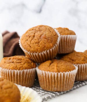 pumpkin muffins stacked on a wire cooling rack