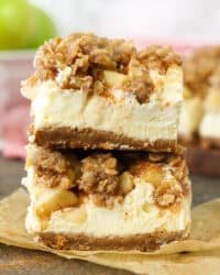 Two caramel apple cheesecake bars stacked on top of one another.