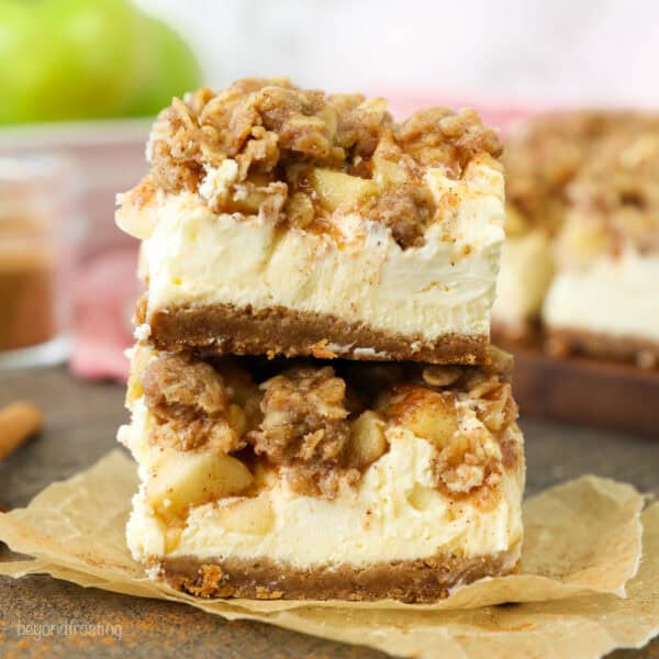 Two caramel apple cheesecake bars stacked on top of one another.