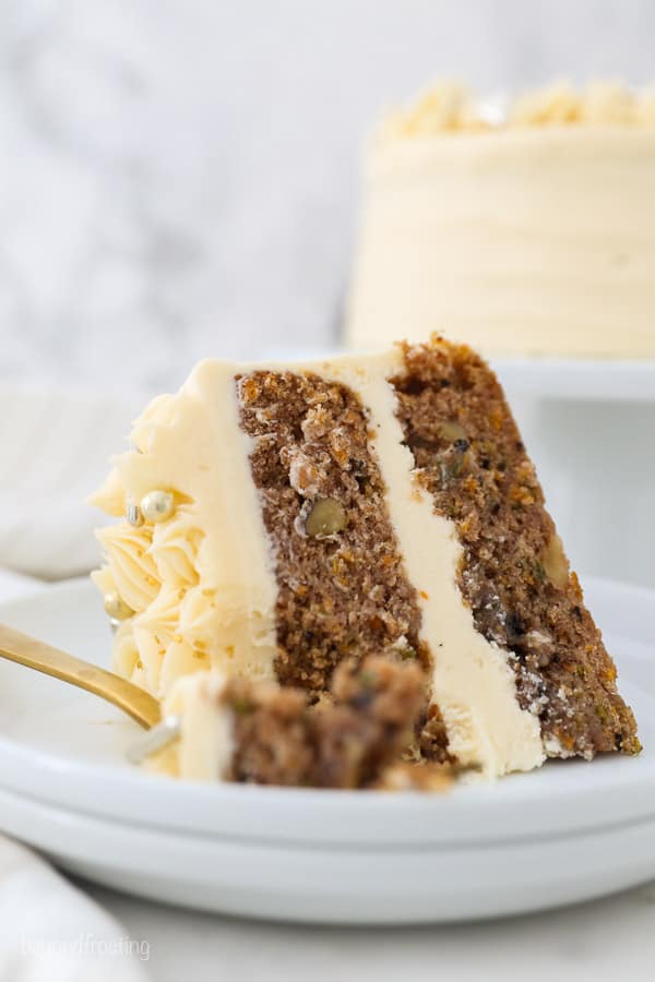 a slice of cake with bite missing, sitting on a white plate