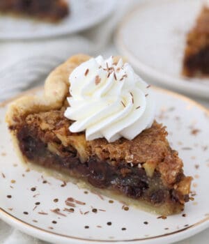 An overhead shot of a slice of walnut pie with whipped cream on top