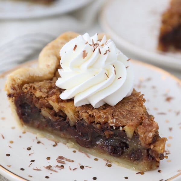 An overhead shot of a slice of walnut pie with whipped cream on top