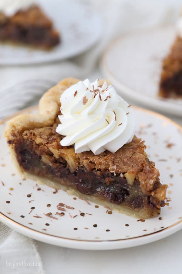 An overhead shot of a slice of walnut pie with whipped cream on top