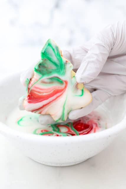 A hand holding a dipped sugar cookie