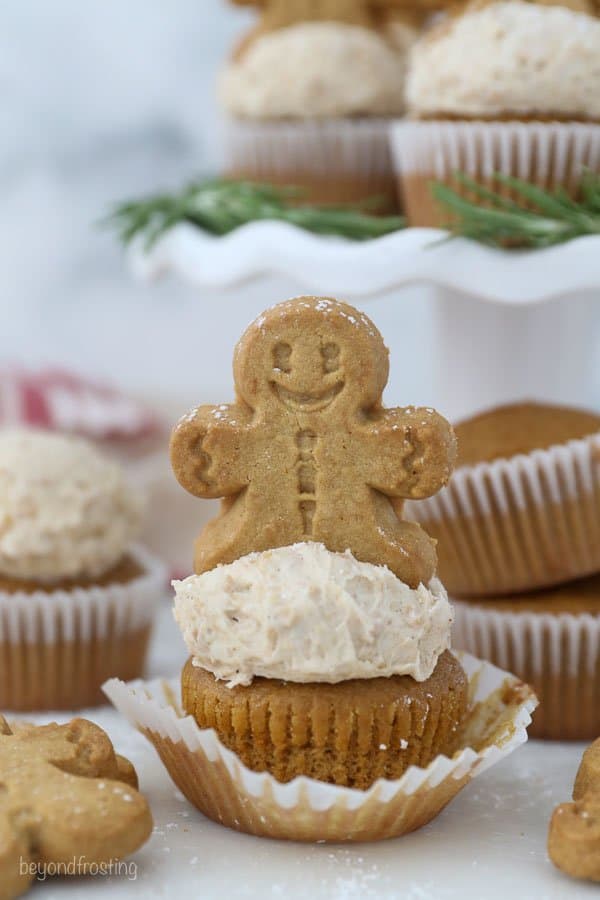 A gingerbread man on top of a frosted cupcake
