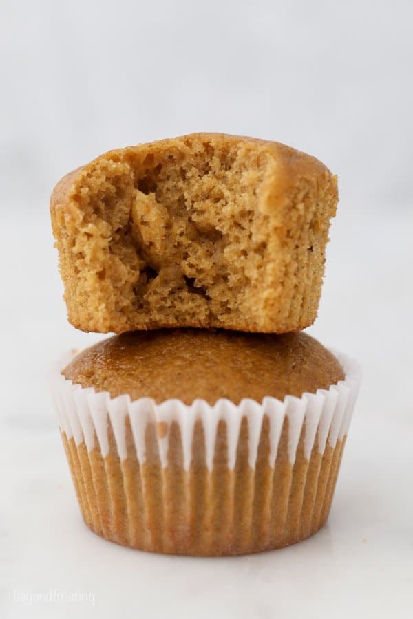 two stacked gingerbread cupcakes, the one on top has a bite missing