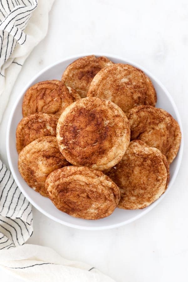 an overhead shot of a white plate full of snickerdoodle cookies