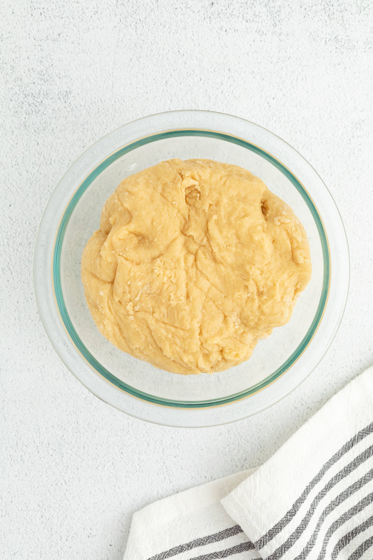 Italian anise cookies are traditional, cake-like Christmas cookies dipped in glaze and topped with sprinkles. Perfect for cookie platters! Anise cookie dough in a glass bpwl.