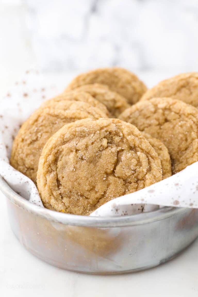 Brown sugar cookies inside a metal bowl lined with a white dishcloth.