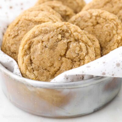 Brown sugar cookies inside a metal bowl lined with a white dishcloth.