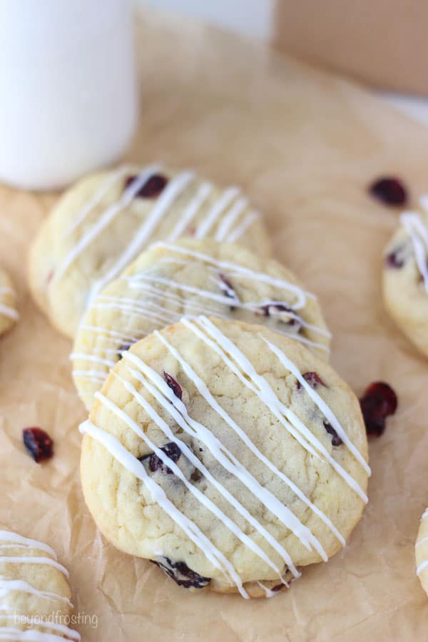 cranberry orange cookies laid on brown parchment paper