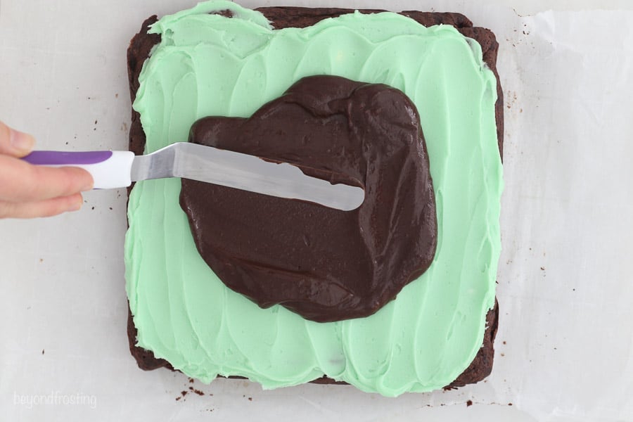 A top view of a knife spreading chocolate ganache