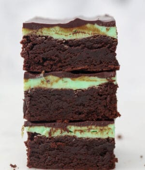 A stack of 3 brownies with mint frosting