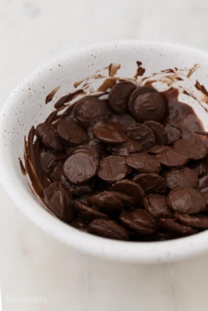 A White Bowl Full of Melty Dark Chocolate Wafers
