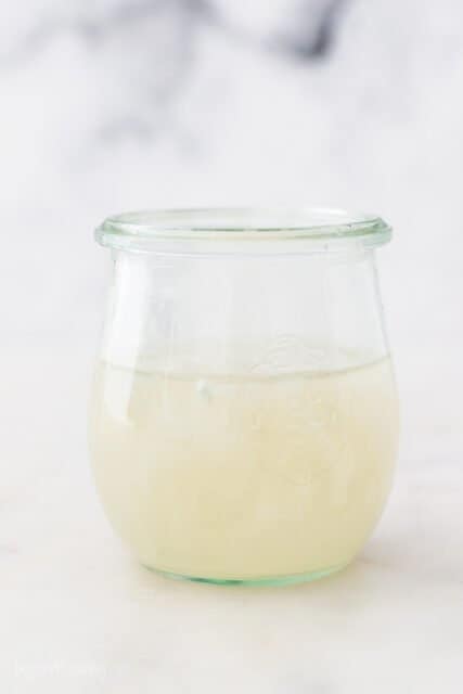 Coconut Water in a Drinking Glass Sitting on a White Surface