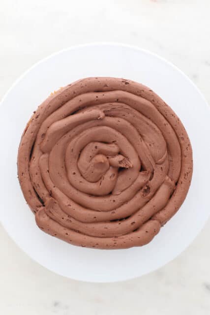 Chocolate frosting piped in a swirl overtop a marble cake layer.