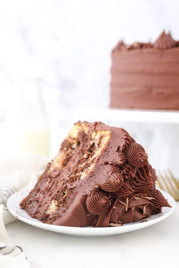 a close up of a chocolate frosted cake with rosettes