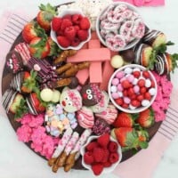 Overhead shot of a dessert charcuterie board for Valentine's day with candy, fruit and cookies