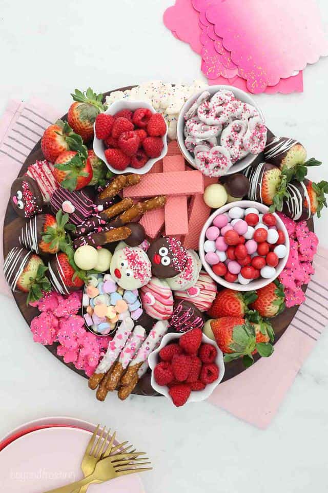 Overhead shot of a dessert charcuterie board for Valentine's day with candy, fruit and cookies