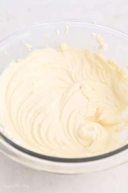 Cheesecake batter in a glass mixing bowl.