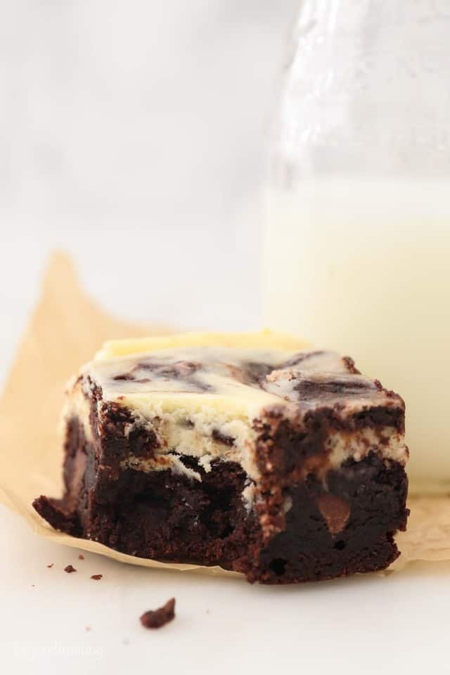 A close up of a cheesecake brownie with a bite taken out of it