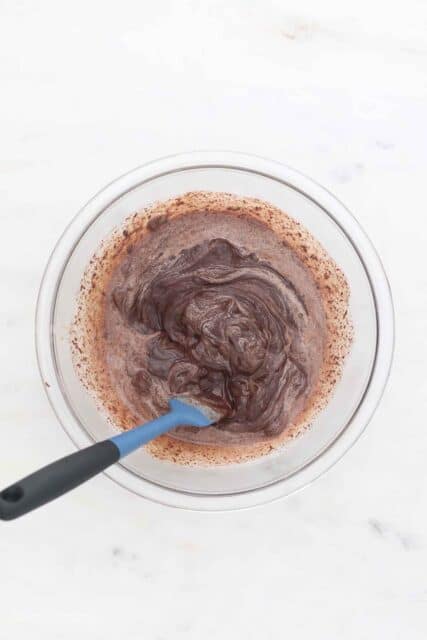 Pieces of Chocolate Being Melted by Heavy Cream in a Large Mixing Bowl