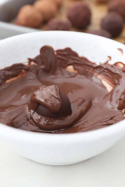 A Truffle Inside a White Bowl of Melted Chocolate