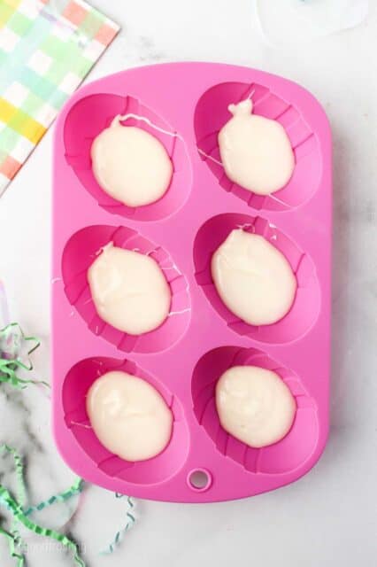 a pink Easter egg mold filled with white chocolate