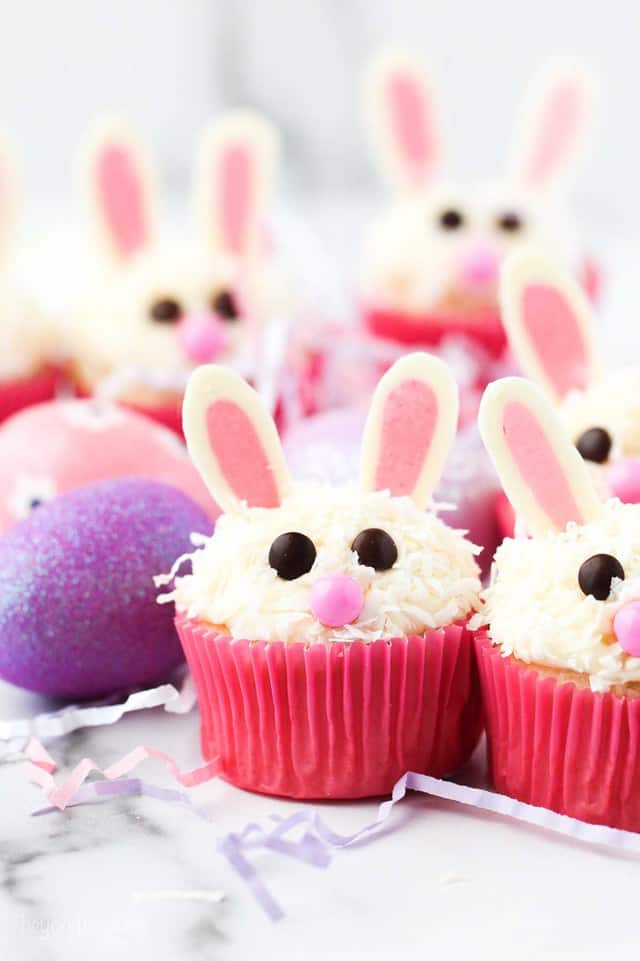 cupcakes decorated like bunnies with pink wrappers