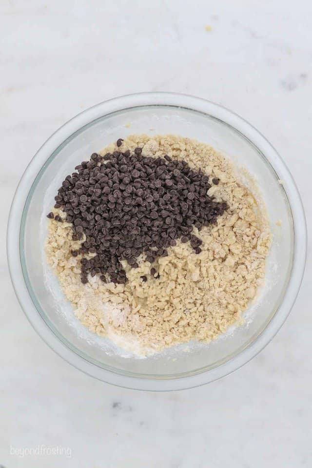 How to make edible cookie dough that's egg-free, including four delicious flavor variations. Easy to make and freezer-friendly! Chocolate chips added to edible cookie dough in a bowl.