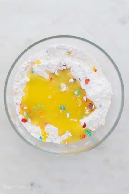 glass bowl with flour, Fruity Pebbles and melted butter