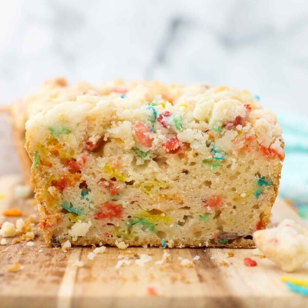 a sliced loaf of Fruity Pebble pound cake showing the inside of the cake