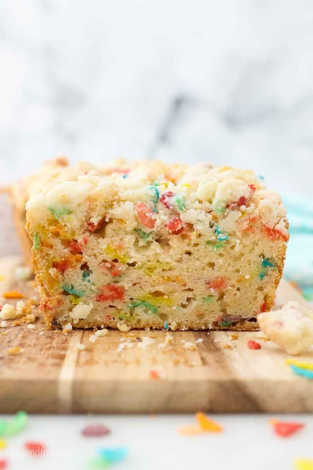 a sliced loaf of Fruity Pebble pound cake showing the inside of the cake