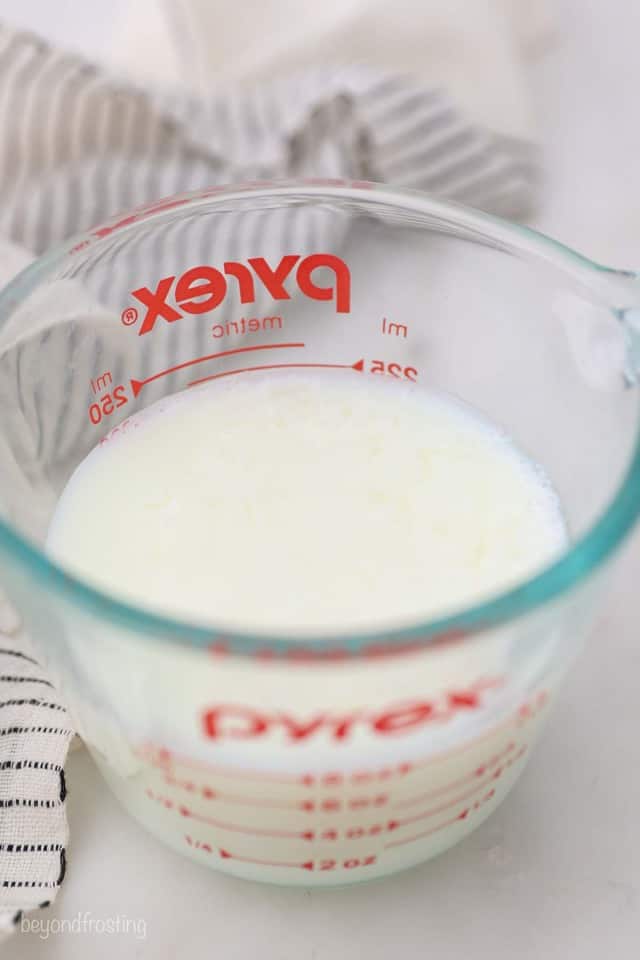 Homemade Buttermilk in a Glass Measuring Cup with Red Text