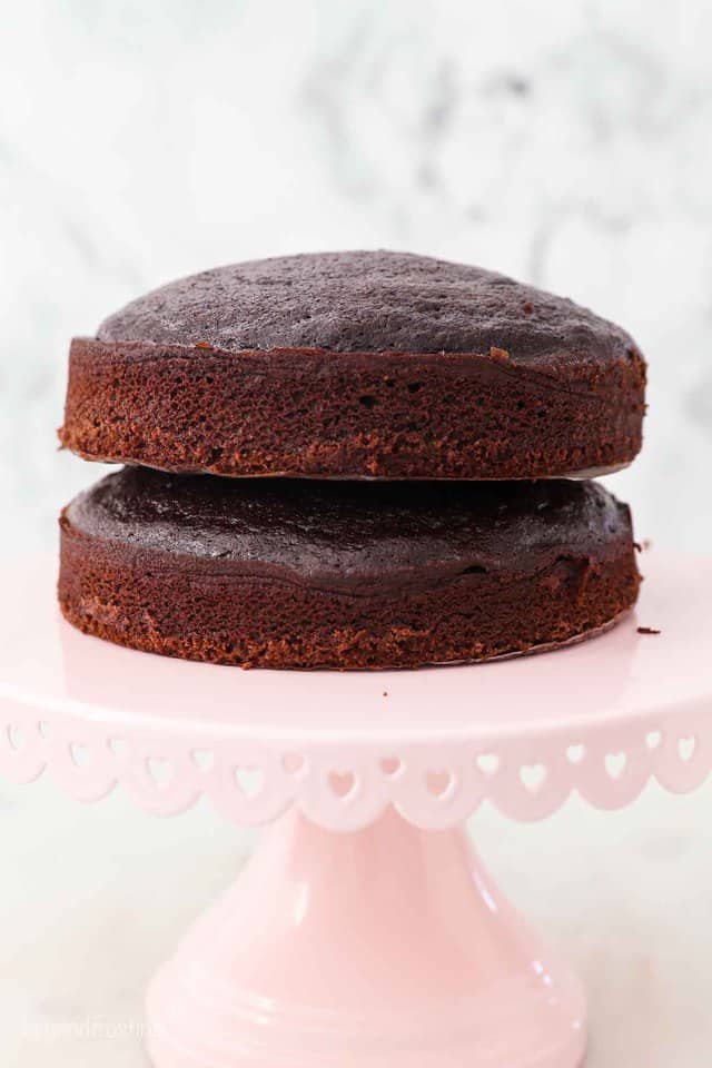 Two Mini Chocolate Cake Layers on a Light Pink Cake Stand with Heart Cut Outs