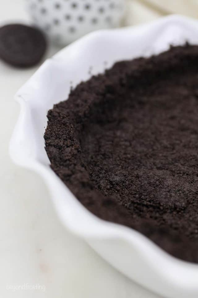 A Close-Up Shot of an Oreo Crust Inside of a White Pie Plate